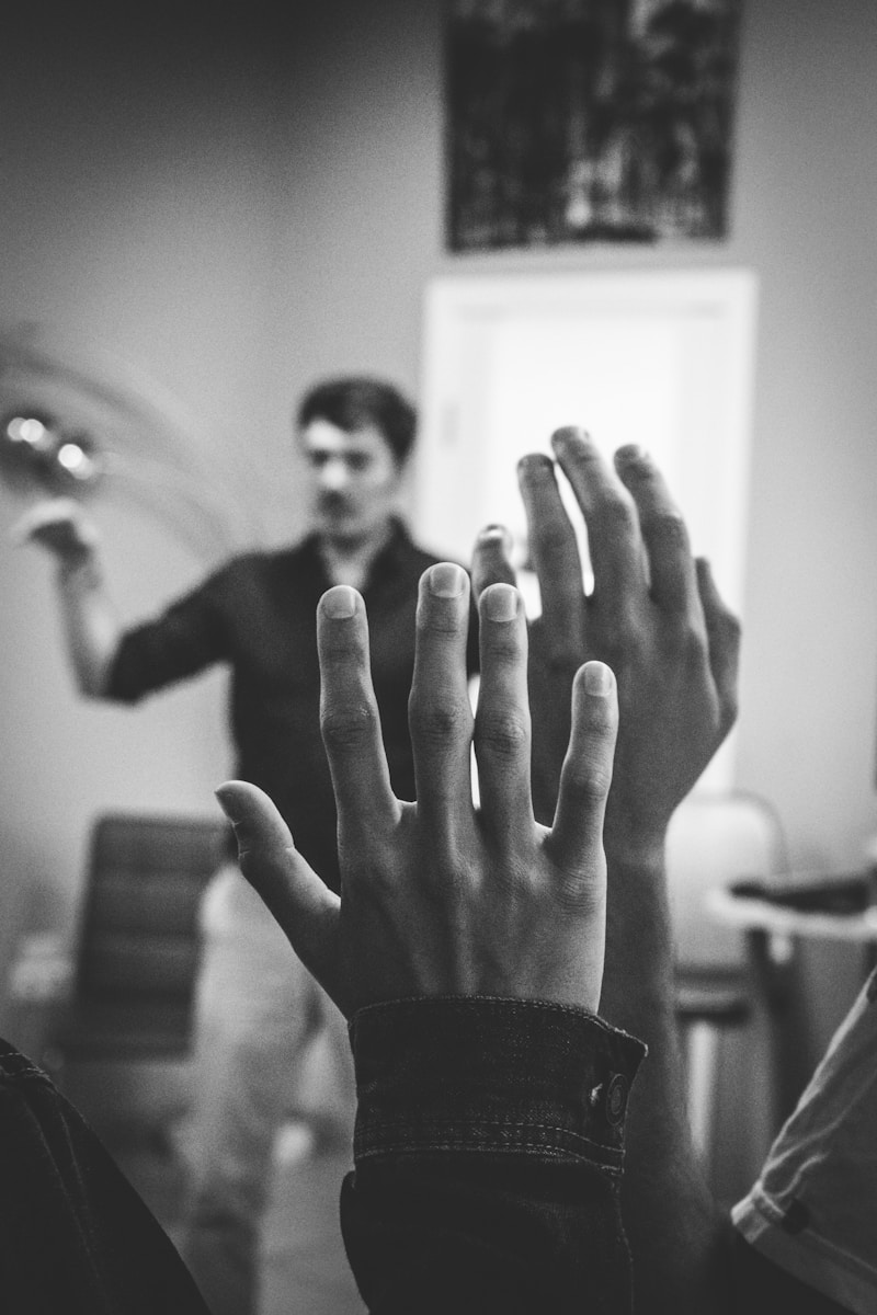 Photo by Artem Maltsev grayscale photography of two people raising their hands